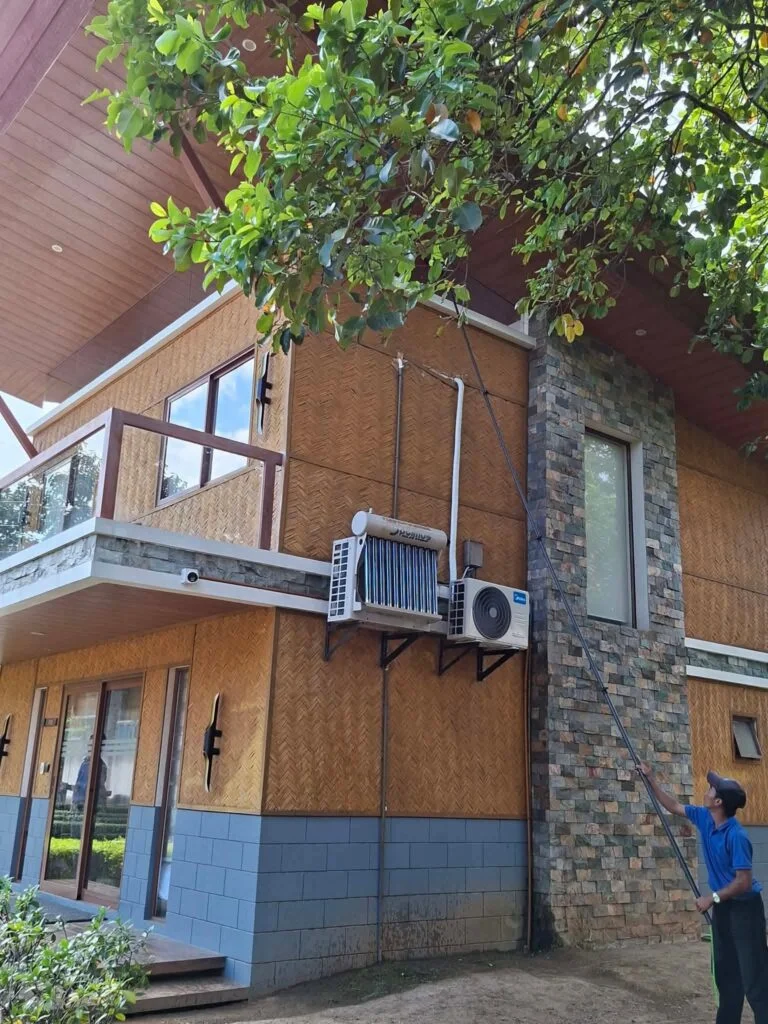 TopMop crew using a water-fed pole on accommodation-building windows at Estancia de Lorenzo