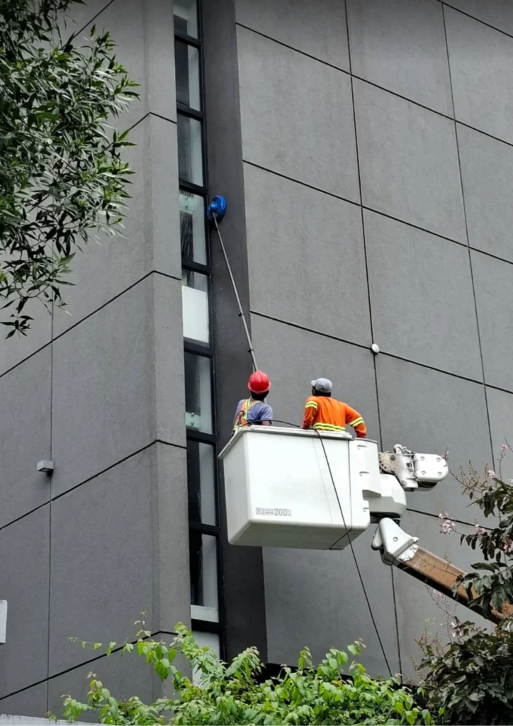Manlift access beside elevated facade panels and windows in Valenzuela