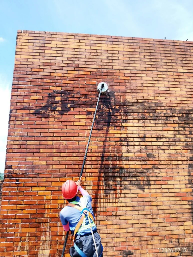 Close view of rotating surface cleaning in progress on brickwork